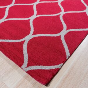 A red rug with a prominent gray geometric lattice pattern lies on light blonde wood flooring.
