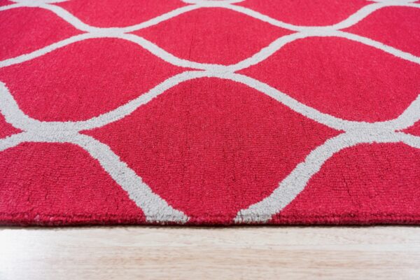 Bright pink medium pile rug featuring a repeating gray quatrefoil pattern on light wood flooring.