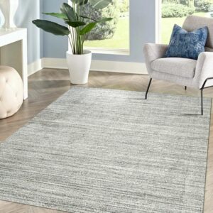 Light gray rug with horizontal linear texture on wood floors, framed by blue walls and a gray chair.