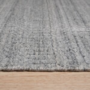 Speckled gray low-pile rug featuring a subtle rectangular pattern rests on light blonde wood flooring.