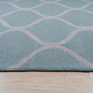 Aqua rug with a light gray curved lattice pattern lies on pale plank flooring.