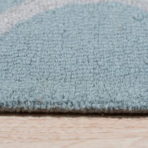 Light blue and gray textured rug edge rests on light wood flooring.