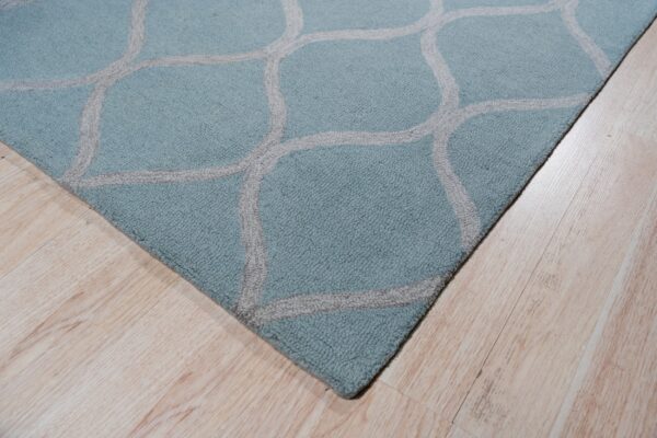 Textured aqua rug with a gray trellis pattern resting on pale wooden plank flooring.