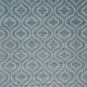 Muted blue pile rug featuring a repeating light blue geometric quatrefoil pattern and visible white fringe.