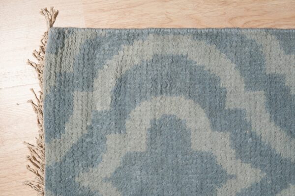 High-pile shag rug in light blue and gray abstract patterns rests on wood flooring.