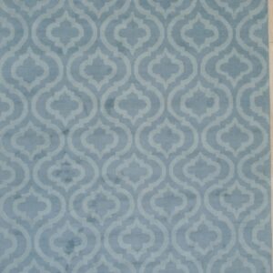 Light blue rug with tone-on-tone geometric ogee pattern laid flat on pale wood flooring.