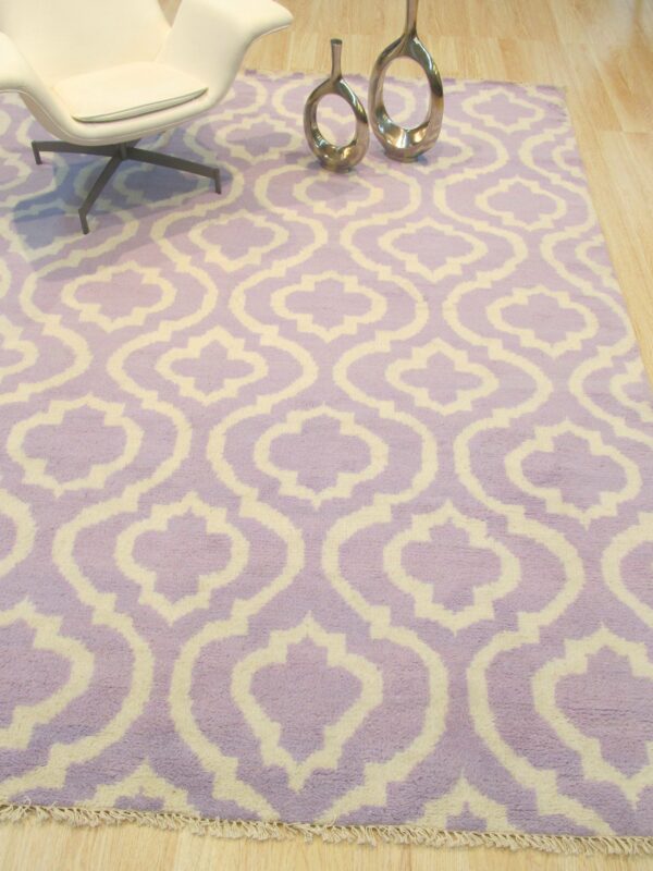Plush purple and cream rug featuring a bold geometric trellis pattern on light wood flooring.