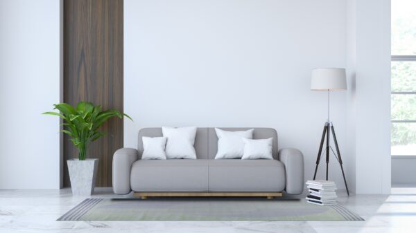 Modern room with a striped green and lavender rug under a gray couch and white pillows on marble flooring.