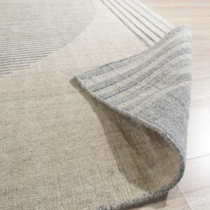 Textured beige rug with subtle gray stripes, partially rolled back on light wood flooring.