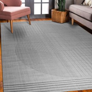A low-pile gray rug with subtle geometric striped patterns anchors a room with wood floors and modern seating.