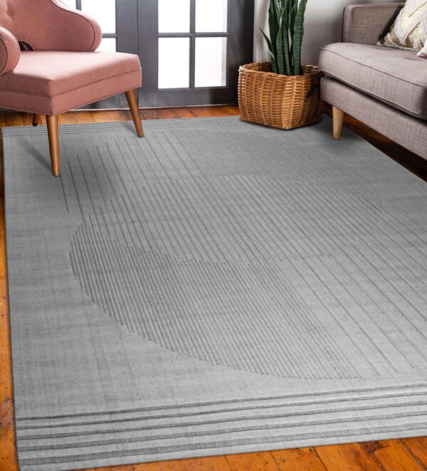 A low-pile gray rug with subtle geometric striped patterns anchors a room with wood floors and modern seating.