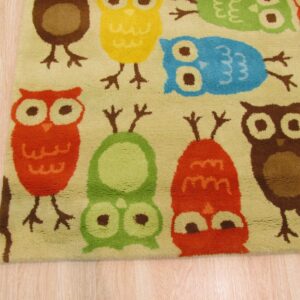 Medium pile rug with a multicolor owl pattern in red, yellow, green, and blue on light wood planks.