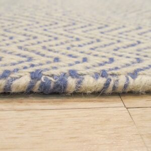 Chunky, textured cream and blue chevron rug edge rests on light plank flooring.