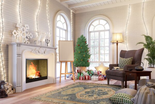 A distressed blue and beige traditional patterned rug sits on wood flooring near a christmas tree and fireplace.
