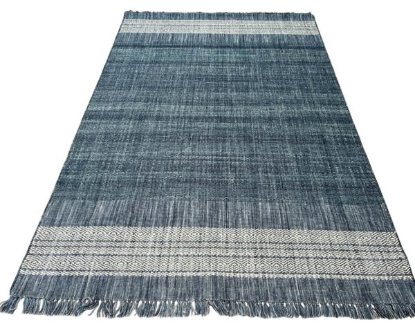Blue woven runner featuring a variegated field and geometric white bands with fringe on the ends.