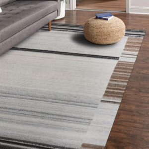 Abstract low-pile rug with light gray, charcoal, and brown horizontal stripes on dark wood flooring.