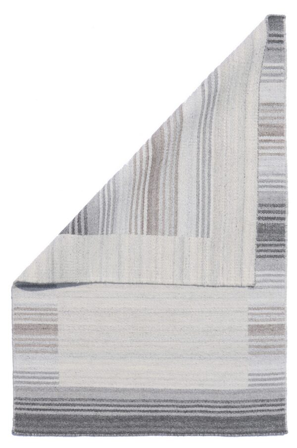 Neutral flatwoven rug folded over, revealing contrasting vertical and horizontal gray and white stripes.