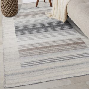 Flatweave rug featuring blocks of thin charcoal, taupe, and cream horizontal stripes on wood flooring.