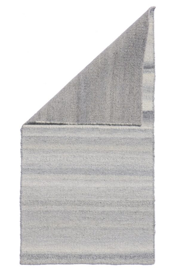 Flatwoven rug with subtle gray and off-white horizontal stripes, folded to show the solid heather gray backing.