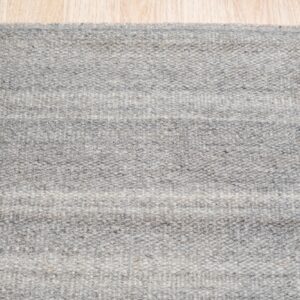 Heathered gray rug with faint horizontal bands displayed on light-toned plank flooring.