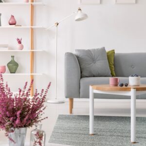A gray and white flatweave rug in a chevron pattern rests beneath a modern sofa and wood coffee table.