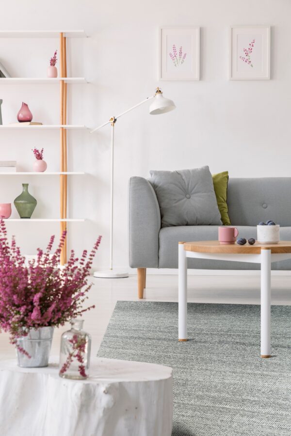 A gray and white flatweave rug in a chevron pattern rests beneath a modern sofa and wood coffee table.