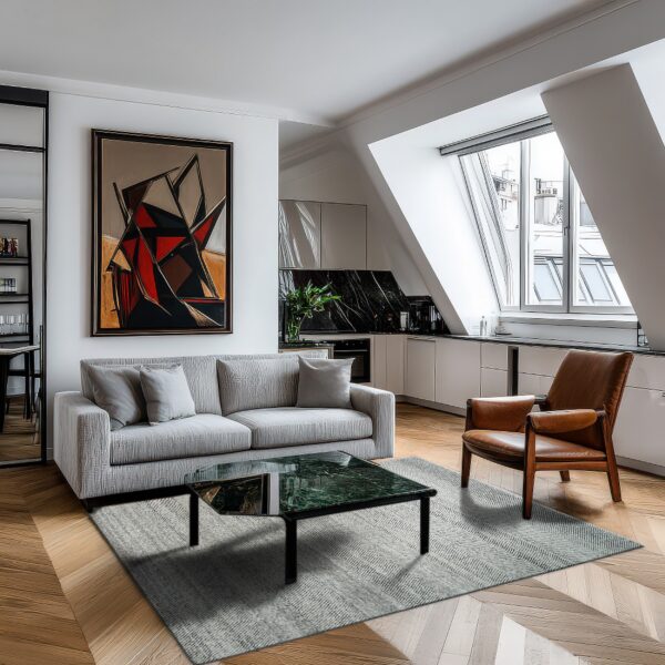 A light gray woven rug anchors a modern living space with a sofa, leather armchair, and wood chevron floor.