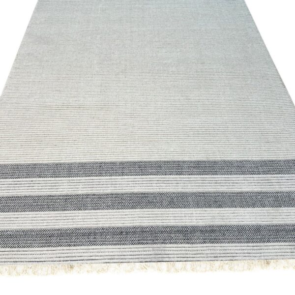 Light gray flatweave rug with thin horizontal stripes and three lower black and white patterned bands near the fringe.