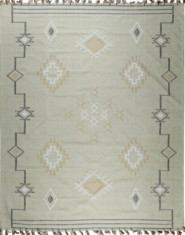 A light sage green flatwoven rug displays geometric diamond patterns in black, white, and tan, finished with tassels.