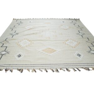 Beige flatweave rug with black, white, and tan geometric diamond patterns and tassels.