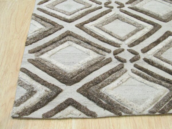 Beige rug with chunky raised brown and cream diamond patterns sits on light blonde wood planks.