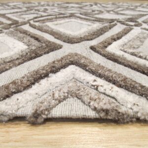 A textured gray rug with dark brown shaggy geometric patterns rests on light wood flooring.