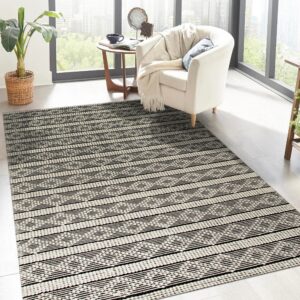 Black and off-white horizontal stripe rug with geometric patterns in a sunny room with light wood floors.