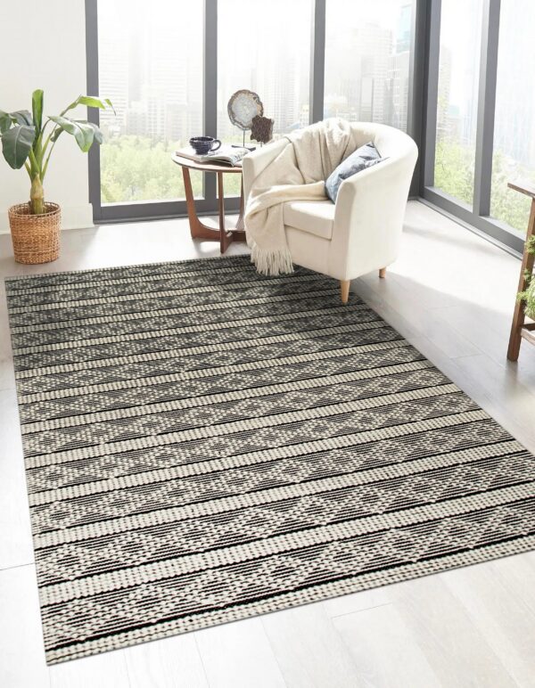 Black and off-white horizontal stripe rug with geometric patterns in a sunny room with light wood floors.