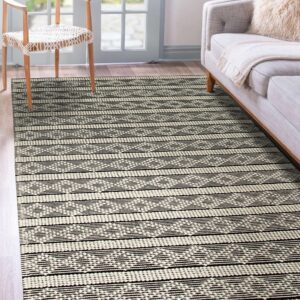 Black and ivory textured rug with geometric stripes under a wooden chair and gray couch.