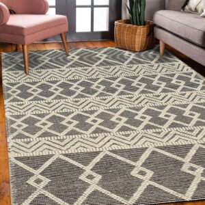 Geometric black and off-white patterned rug anchors a living area with pink and gray upholstered furniture.