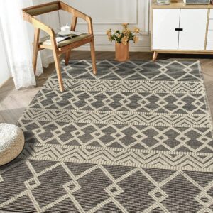 Black and cream geometric low pile rug featuring banded diamond patterns in a bright room.