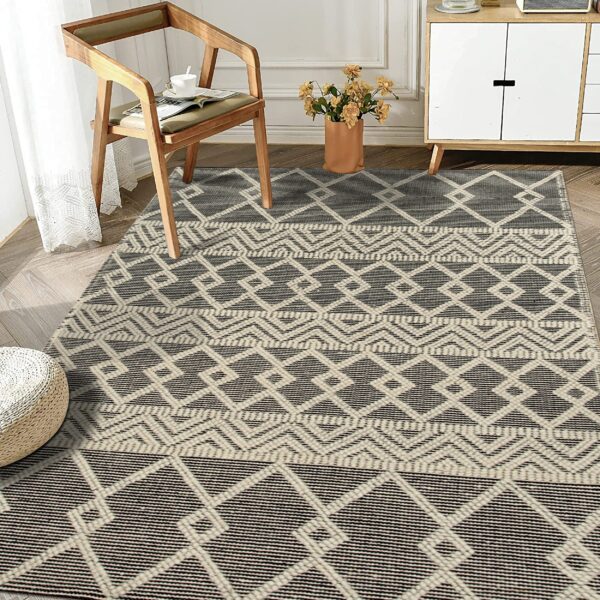 Black and cream geometric low pile rug featuring banded diamond patterns in a bright room.