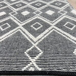 Black and white geometric rug with raised white diamond patterns lying on light wood floor.