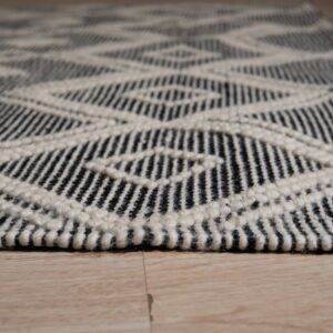 Black and cream chunky low pile rug featuring a geometric diamond pattern on light wood floor.