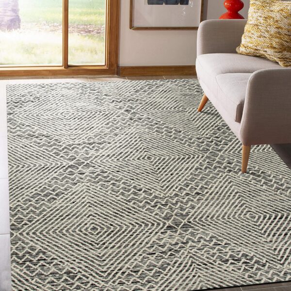 Black and cream geometric rug with nested diamond patterns sits beside a gray sofa near a large window.