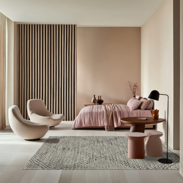 Gray and cream textured rug anchors a contemporary bedroom with curved chairs and pink bedding on light wood floors.