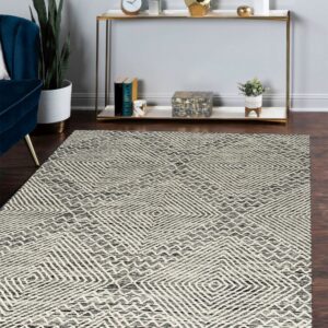 Textured black and cream rug with concentric diamond patterns on dark hardwood flooring in a modern living space.