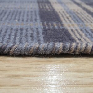 Close-up of a ribbed blue and gray plaid rug edge resting on glossy light wood flooring.