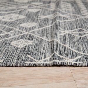 Textured gray rug with raised white geometric lines and diamonds rests on light wood floor.
