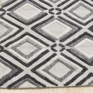 Black, gray, and white textured rug with geometric diamonds resting on light wood floor.