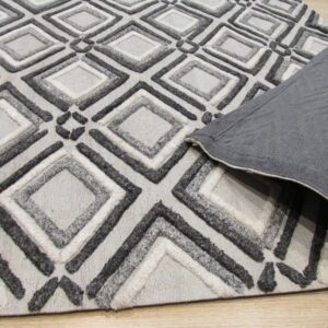 Textured gray geometric rug showing raised diamond pile and a folded dark gray backing on wood floor.