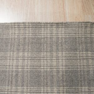 A textured gray low-pile rug with faint cream grid lines rests on light natural wood flooring.