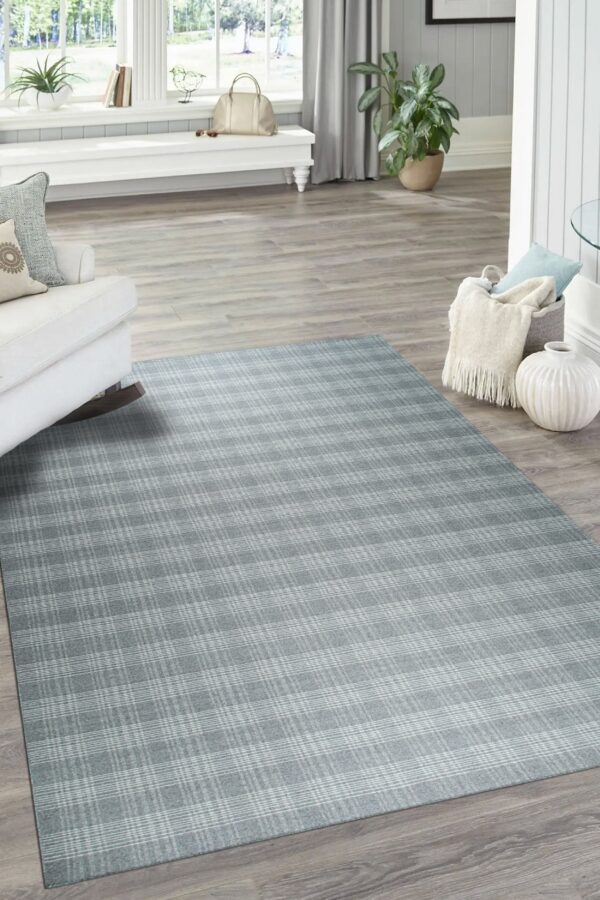 Subtle blue-grey plaid rug displayed on wood plank flooring in a naturally lit living area.