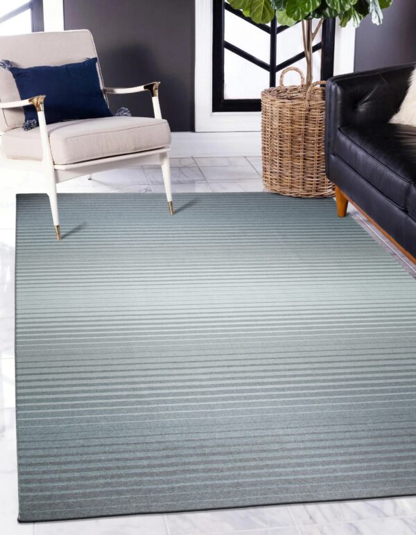 A gradient striped rug transitions from dark teal to light gray, resting beneath furniture on white marble tile flooring.